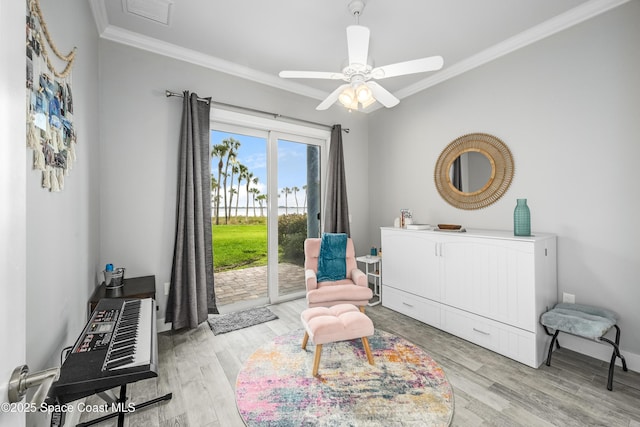 sitting room featuring ceiling fan, light wood-type flooring, and ornamental molding