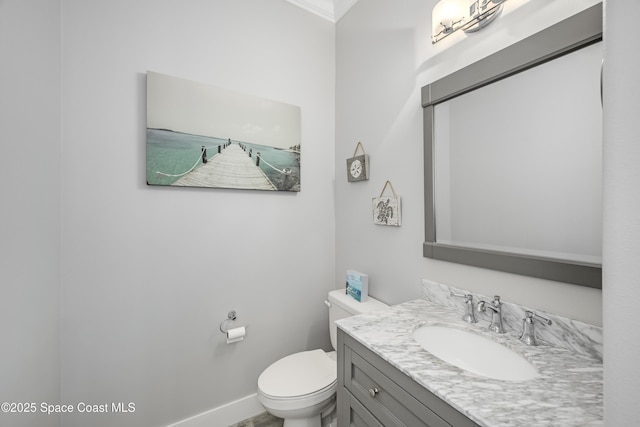 bathroom with vanity, ornamental molding, and toilet