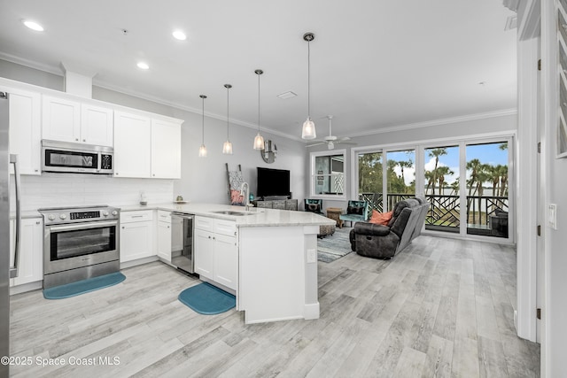 kitchen with kitchen peninsula, decorative light fixtures, stainless steel appliances, and white cabinetry