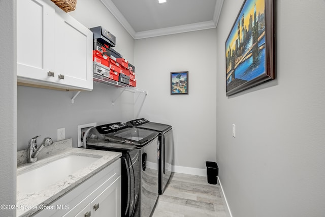 clothes washing area with sink, cabinets, independent washer and dryer, crown molding, and light wood-type flooring