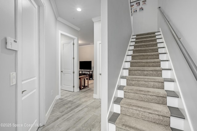 stairs featuring hardwood / wood-style flooring and ornamental molding