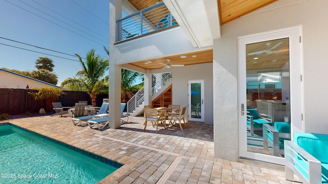 view of swimming pool with ceiling fan and a patio area