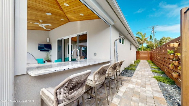 view of patio with ceiling fan and a wet bar