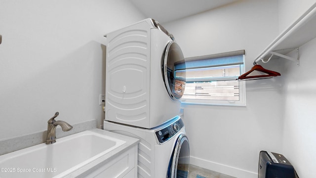 clothes washing area featuring stacked washer and clothes dryer and sink