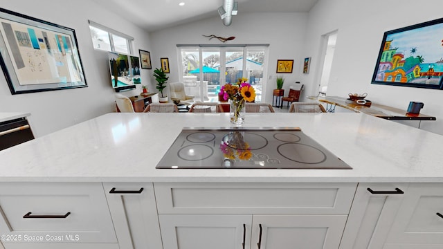 kitchen featuring lofted ceiling, white cabinetry, black electric cooktop, and kitchen peninsula