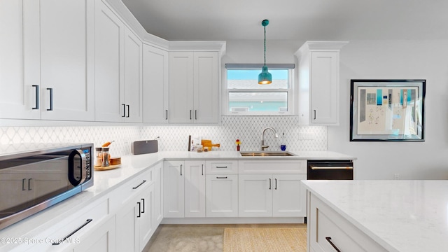 kitchen featuring sink, black dishwasher, tasteful backsplash, pendant lighting, and white cabinets