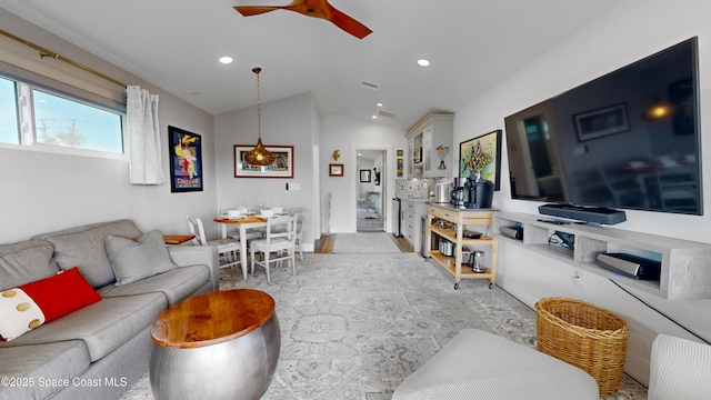 living room featuring ceiling fan and vaulted ceiling