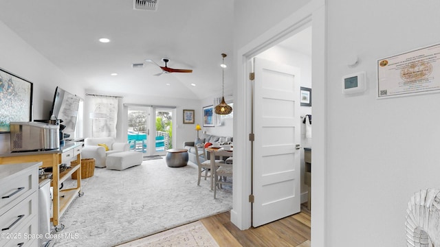 living room featuring ceiling fan, light wood-type flooring, and lofted ceiling