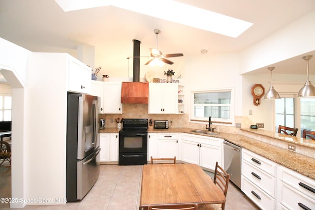 kitchen featuring kitchen peninsula, appliances with stainless steel finishes, sink, pendant lighting, and white cabinets