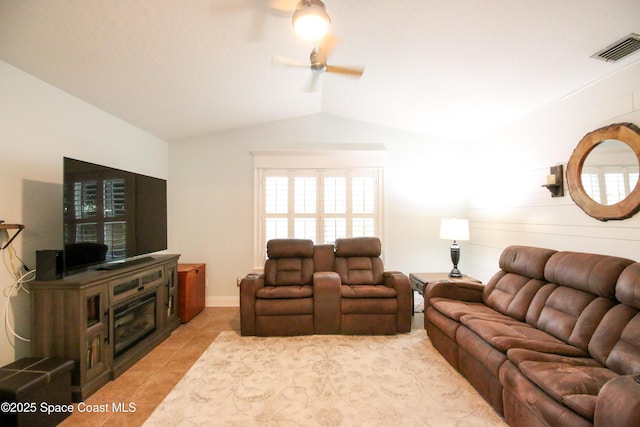 tiled living room with ceiling fan, wood walls, and vaulted ceiling