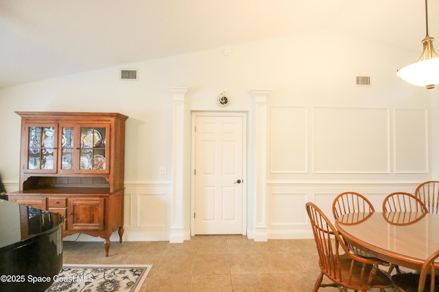 tiled dining room featuring lofted ceiling