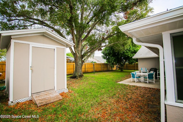 view of yard with a storage shed and a patio