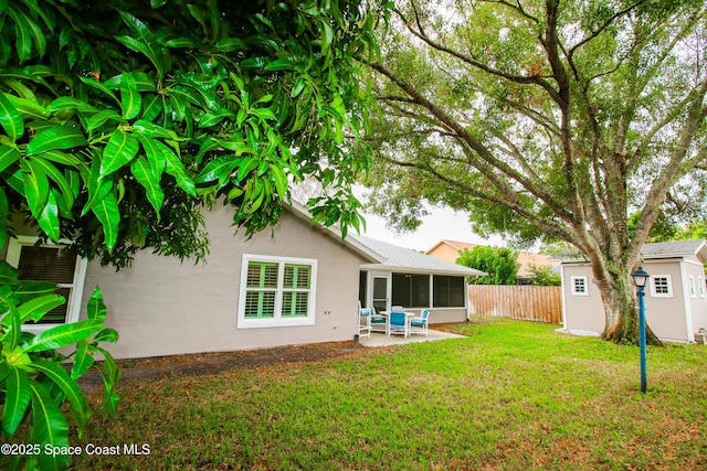 view of yard featuring a sunroom and a patio area