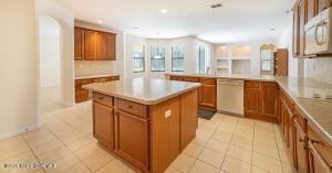 kitchen with white appliances, light tile patterned floors, kitchen peninsula, and a kitchen island