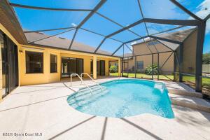 view of pool with glass enclosure and a patio