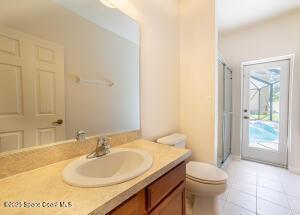 bathroom with walk in shower, toilet, tile patterned floors, and vanity