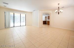 unfurnished room featuring light tile patterned flooring and an inviting chandelier