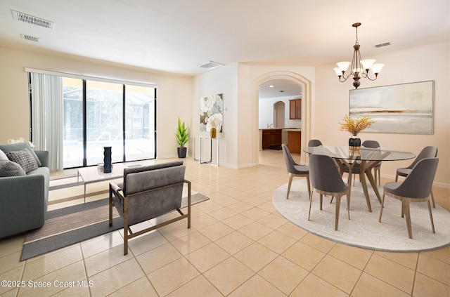 tiled dining room with an inviting chandelier