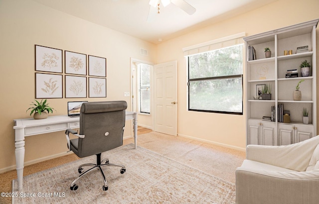 office space with light colored carpet and ceiling fan