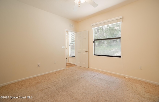 empty room featuring ceiling fan and carpet