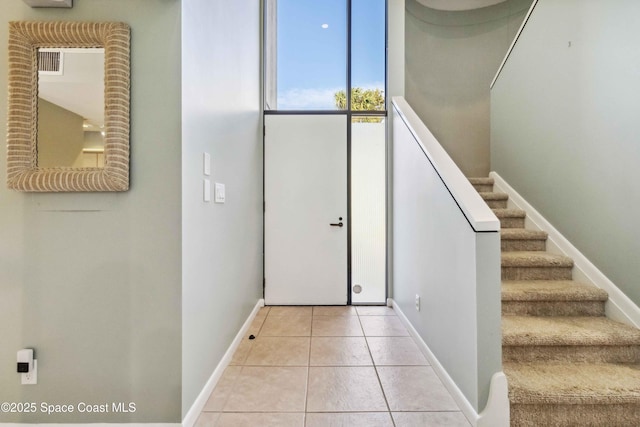 foyer entrance featuring expansive windows and light tile patterned floors