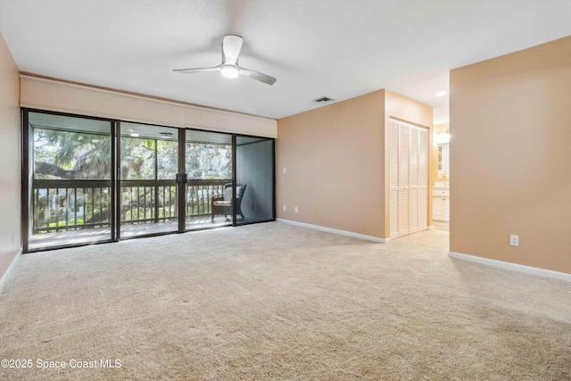 unfurnished room with ceiling fan and light carpet