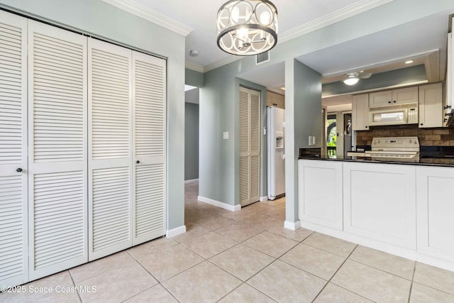 kitchen featuring backsplash, crown molding, a chandelier, pendant lighting, and white appliances