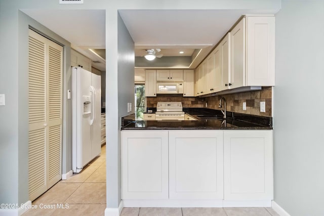 kitchen featuring sink, tasteful backsplash, kitchen peninsula, white appliances, and light tile patterned floors