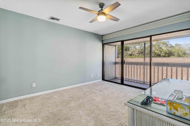 carpeted spare room featuring ceiling fan