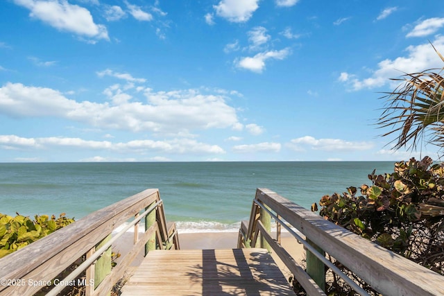 view of property's community with a beach view and a water view