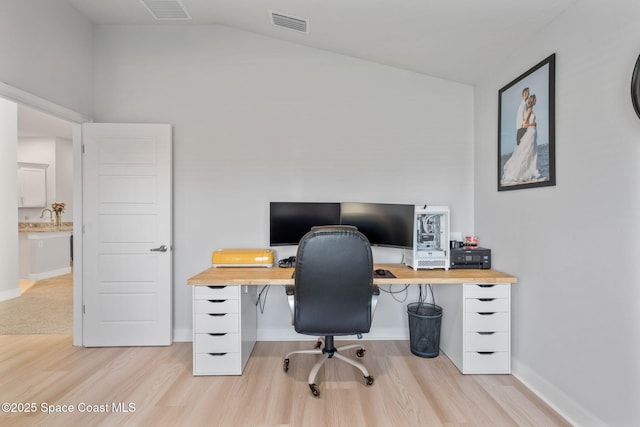 office featuring sink, lofted ceiling, and light wood-type flooring