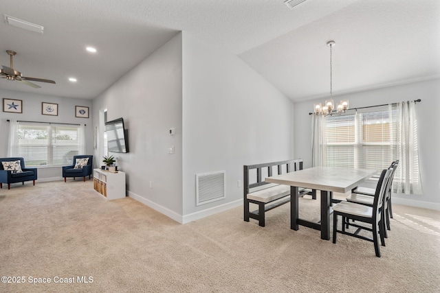 dining room featuring a textured ceiling, ceiling fan with notable chandelier, light colored carpet, and vaulted ceiling