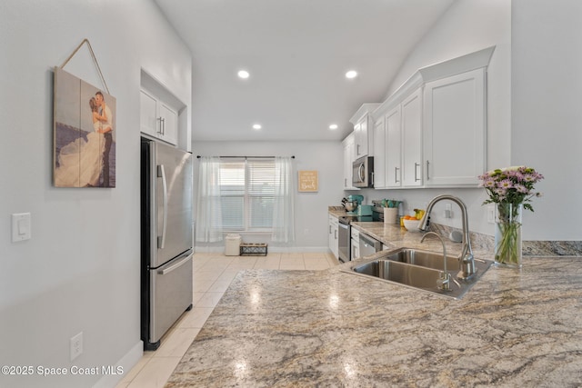 kitchen featuring white cabinetry, sink, light tile patterned flooring, and appliances with stainless steel finishes