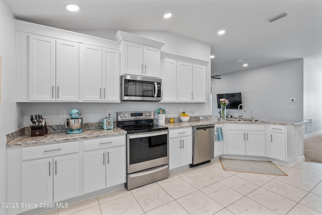 kitchen with kitchen peninsula, white cabinetry, sink, and stainless steel appliances