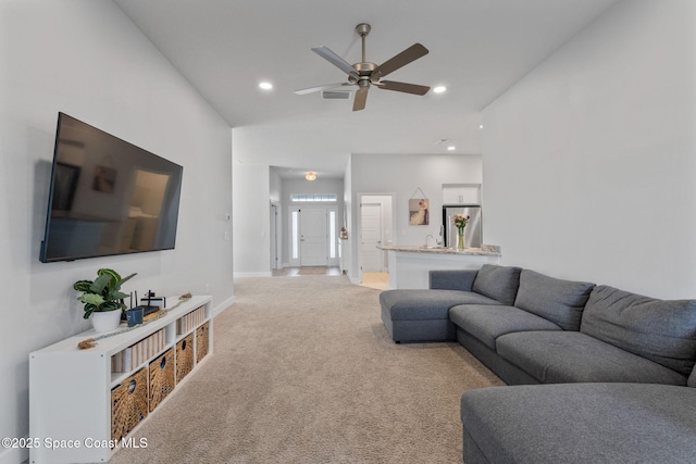 carpeted living room featuring ceiling fan and sink