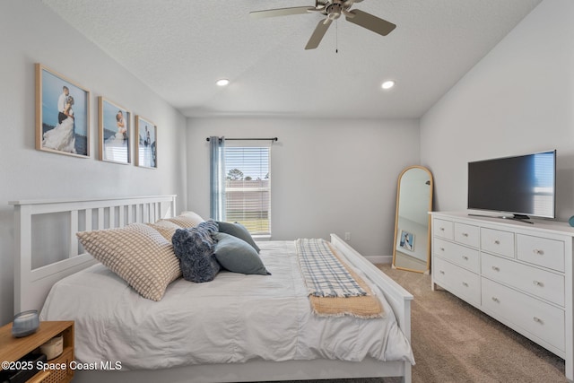 bedroom featuring light carpet, a textured ceiling, and ceiling fan