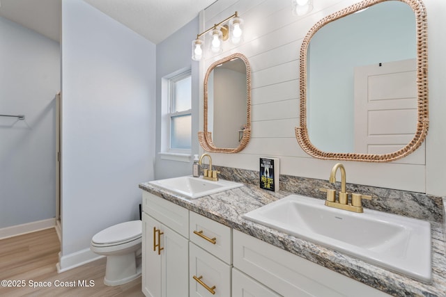 bathroom with hardwood / wood-style flooring, vanity, and toilet