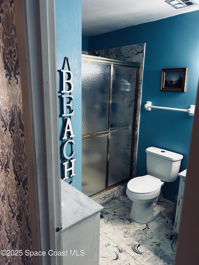 bathroom featuring a stall shower, marble finish floor, vanity, and toilet