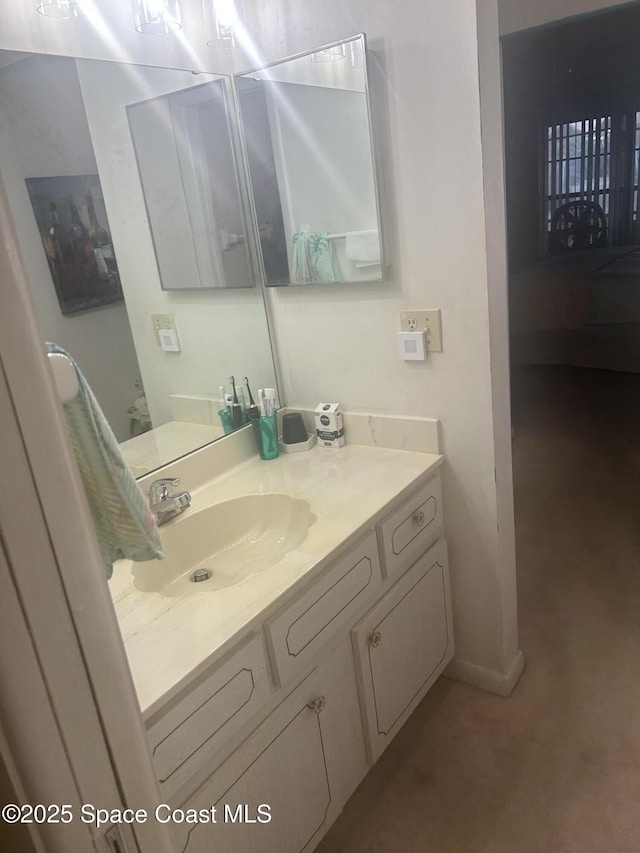 ensuite bathroom with vanity, baseboards, and ensuite bathroom