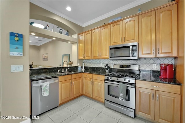 kitchen with appliances with stainless steel finishes, backsplash, dark stone counters, and sink