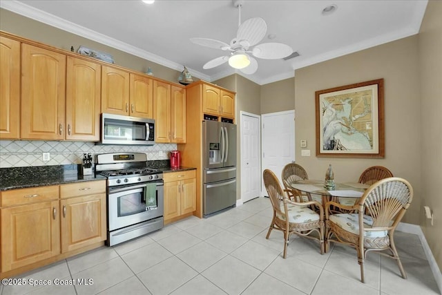 kitchen featuring ceiling fan, dark stone countertops, light tile patterned floors, appliances with stainless steel finishes, and tasteful backsplash