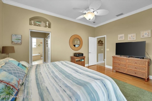 bedroom with hardwood / wood-style flooring, ceiling fan, crown molding, and ensuite bath