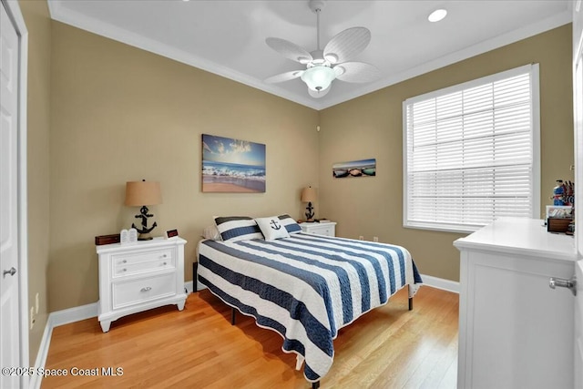 bedroom featuring ceiling fan, light wood-type flooring, crown molding, and multiple windows