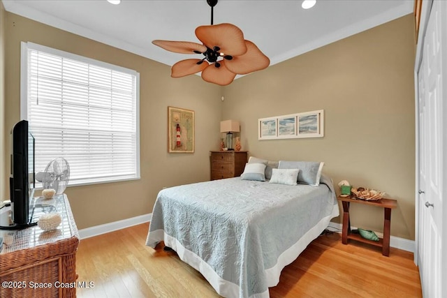 bedroom featuring ceiling fan, light hardwood / wood-style floors, and ornamental molding