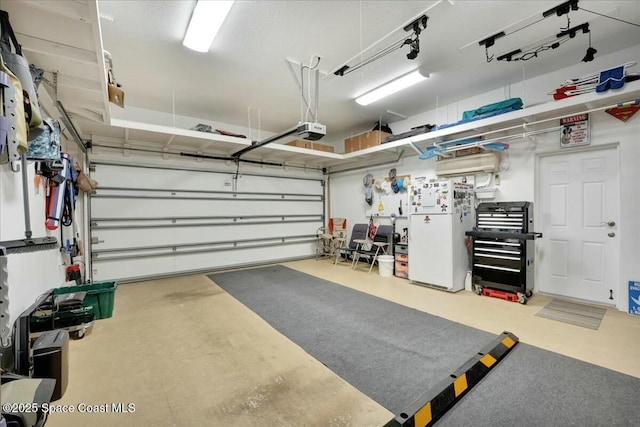 garage with white refrigerator and a garage door opener