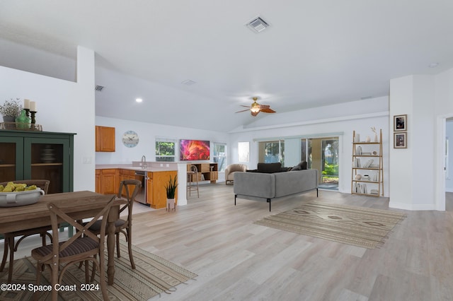 living room featuring ceiling fan, light hardwood / wood-style floors, and vaulted ceiling