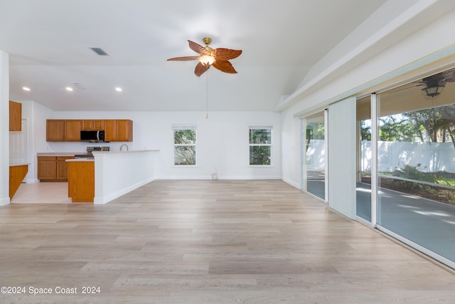 unfurnished living room with ceiling fan, light hardwood / wood-style flooring, and vaulted ceiling