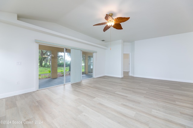 empty room with ceiling fan, light hardwood / wood-style flooring, and vaulted ceiling