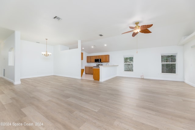 unfurnished living room featuring ceiling fan with notable chandelier, light hardwood / wood-style flooring, and lofted ceiling