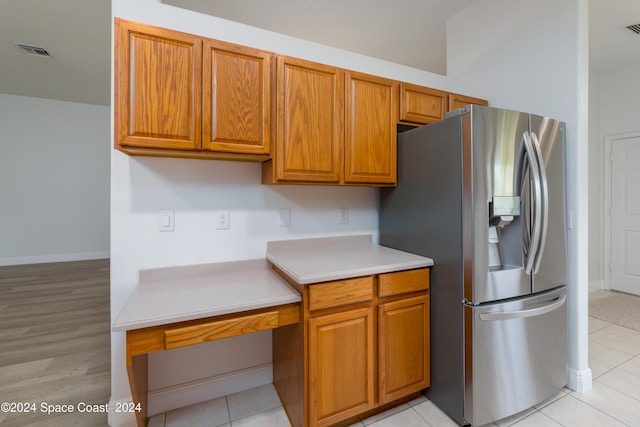 kitchen with stainless steel fridge with ice dispenser and light tile patterned flooring